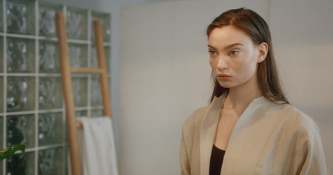 Illustrative video of a person smoothing cream over the cheeks and jaw.