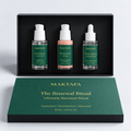 The Renewal Ritual: three products fitted inside an open black presentation box, beside its emerald lid.