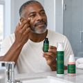 Person applying eye cream beneath an eye, with the Resilience Ritual products beside the basin.