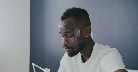 Illustrative video of a person massaging cream across the forehead.