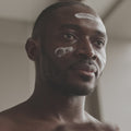 Illustrative video of a person massaging cream over the cheeks and forehead.