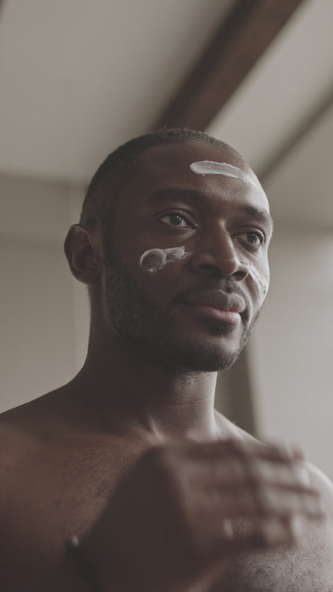 Illustrative video of a person massaging cream over the cheeks and forehead.