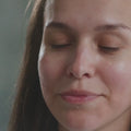 Illustrative video of a person applying skincare to the forehead and cheeks.