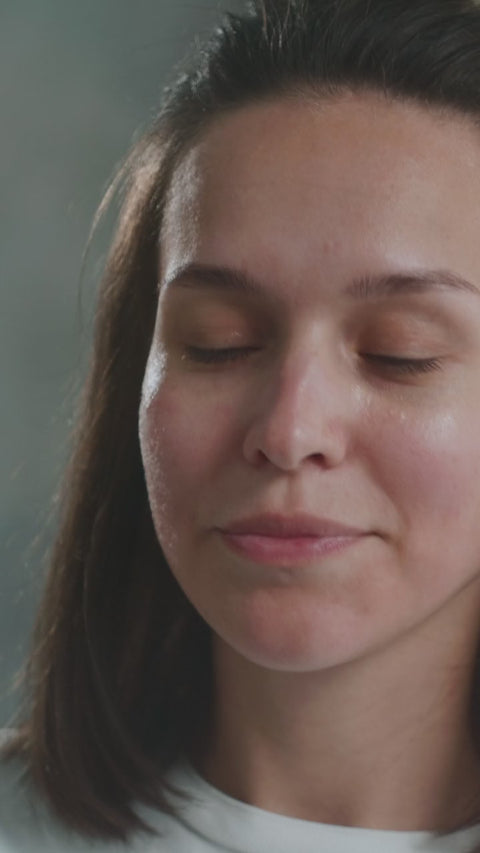 Illustrative video of a person applying skincare to the forehead and cheeks.