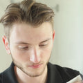 Illustrative video of a person applying skincare across the face in front of a mirror.