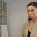 Illustrative video of a person smoothing cream over the cheeks and jaw.